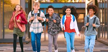 Group of smiling middle school students walking in the hallway